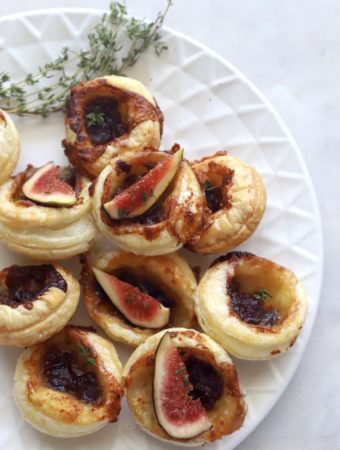 Fig and brie puff pastry bites served with fresh fig slices.