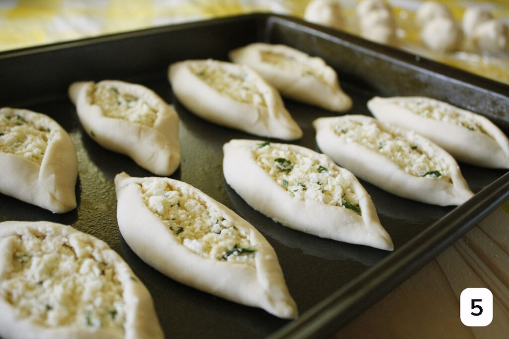 A sheet pan of unbaked cheese fatayer ready for the oven.