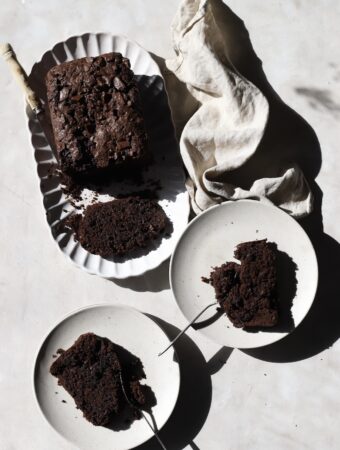 The sliced chocolate zucchini loaf with a piece in each of the two side plates.