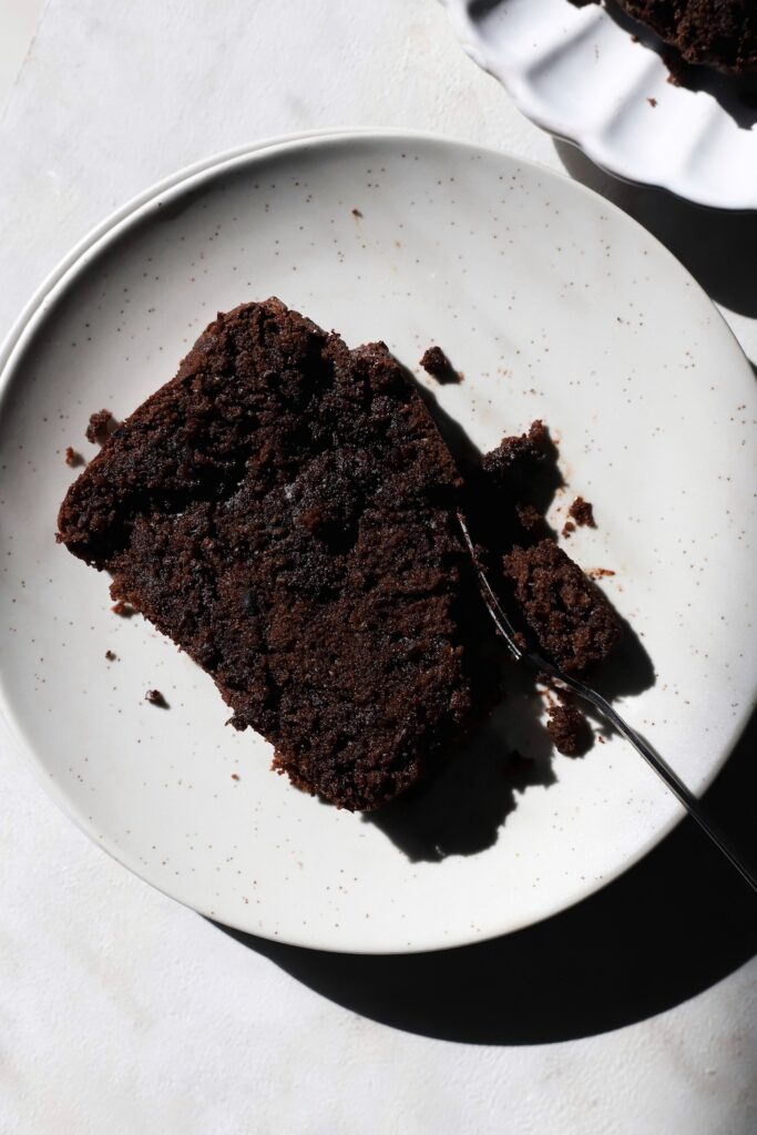 Top down view of a slice of double choc zucchini bread in a plate with a fork.