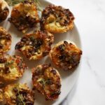 Baked Camembert and mushroom tartlets served warm on a plate.