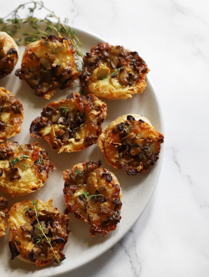 Baked Camembert and mushroom tartlets served warm on a plate.