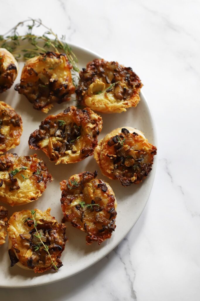 Baked Camembert and mushroom tartlets served warm on a plate.