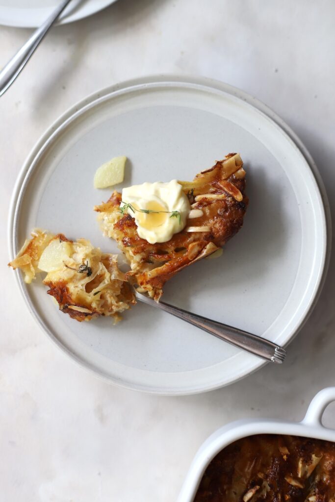 A serve of the tart with a dollop of cream and drizzle of honey.